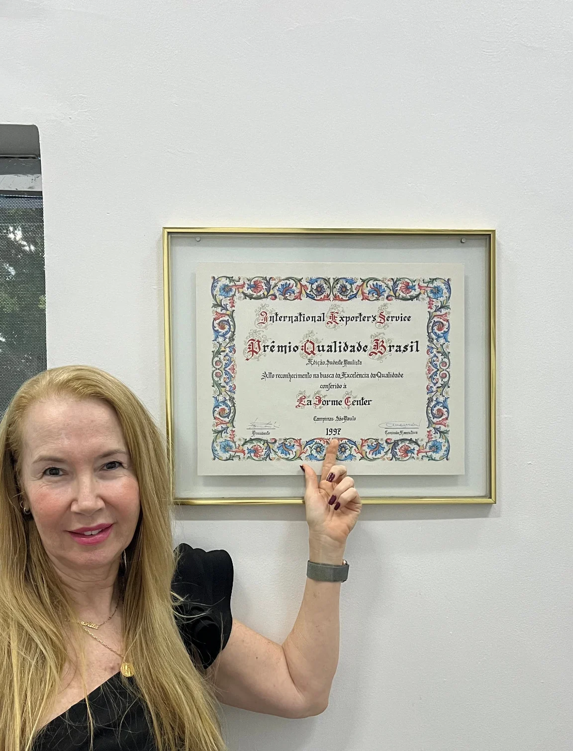 Rita Caride ao lado de uma premiação histórica da La Forme Center