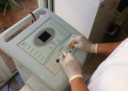 Equipamento utilizado em procedimento de carboxiterapia, com profissional usando luvas